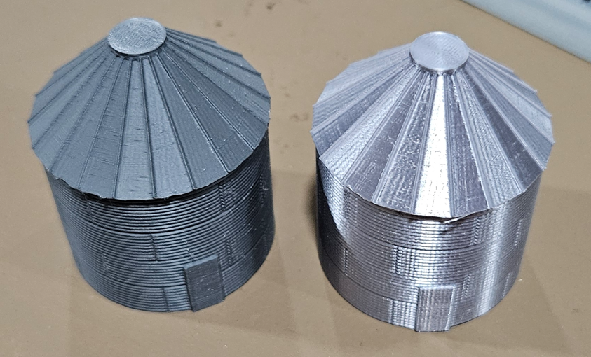 Original 20-foot model railroad silo beside the newer silk-finish version
