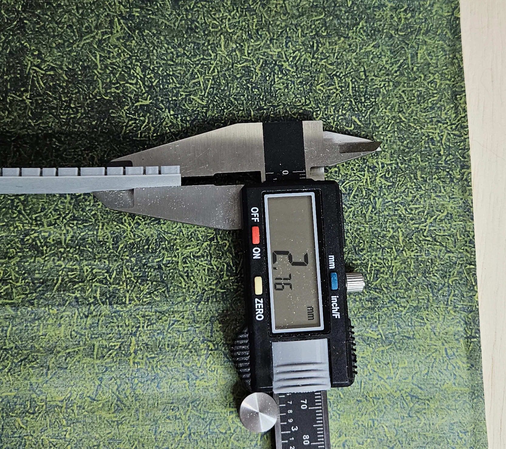 Caliper measuring the HO scale stone wall at approximately 2.76 millimeters thick