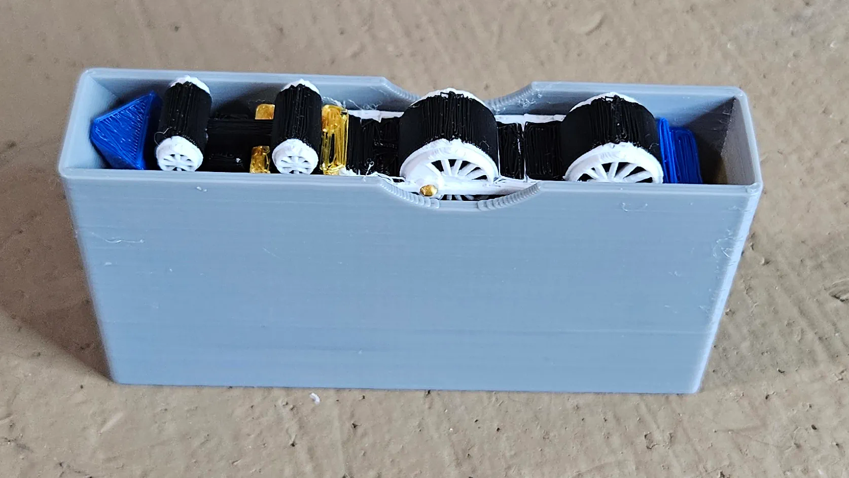 Blue locomotive ornament fitted inside its gray protective cover